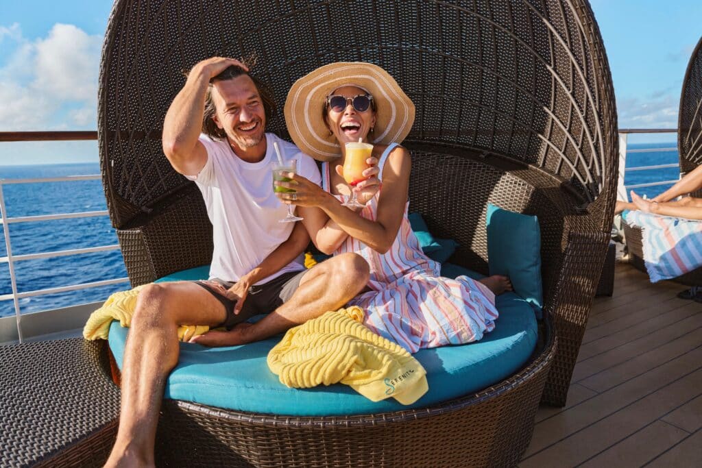 A couple enjoying cocktails on a cruise, dressed in casual daywear